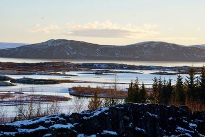 Scenic view of frozen lake against mountains during winter