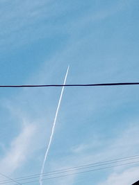 Low angle view of vapor trails against sky