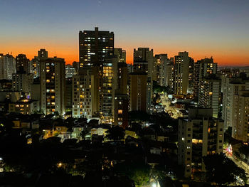 Illuminated cityscape against clear sky at night