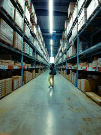 Full length of man standing in distribution warehouse