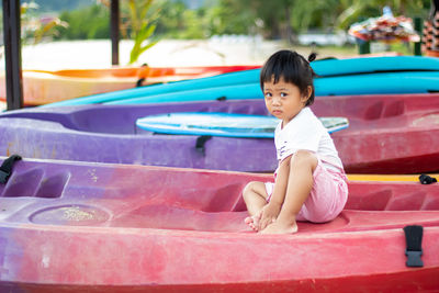 
little asian girl playing on kayak on the beach . relax and smile on kayak on the beach. 