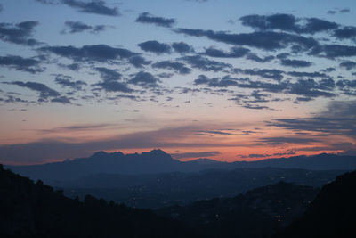 Scenic view of silhouette mountains against sky at sunset