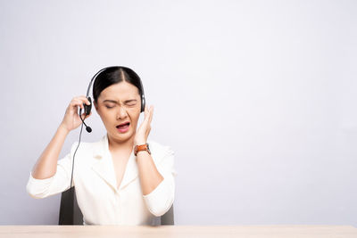 Young woman using smart phone against white background