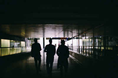 Rear view of friends walking in tunnel