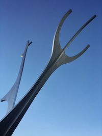 Low angle view of windmill against clear blue sky