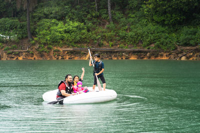 People in boat against trees