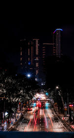 Illuminated city street and buildings at night