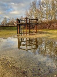 Built structure on field by lake against sky