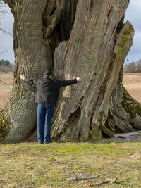 Woman standing on tree trunk