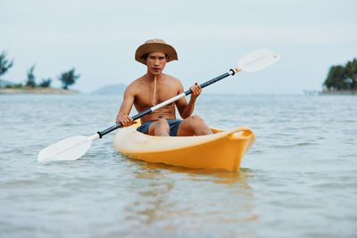 Man kayaking in sea