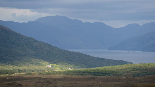 Scenic view of field and mountains against sky