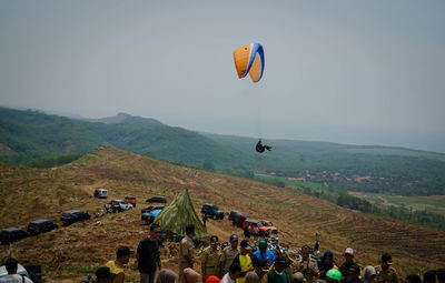 Group of people on mountain against sky