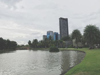 Scenic view of park by buildings against sky