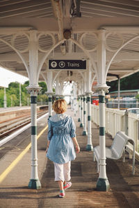 Rear view of woman walking at railroad station platform