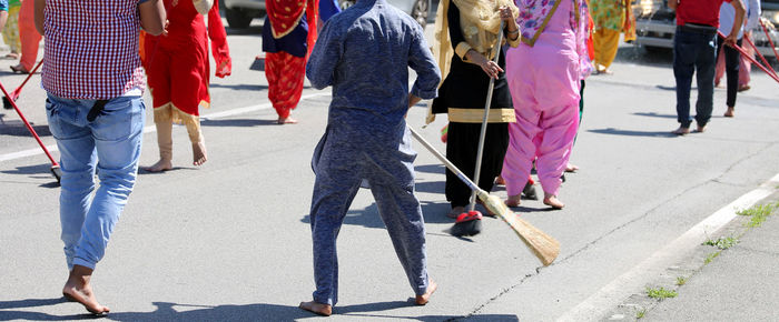 Low section of people walking on sidewalk in city