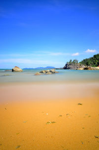 Scenic view of beach against clear blue sky