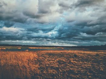 Scenic view of field against cloudy sky