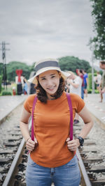 Portrait of smiling woman standing against car