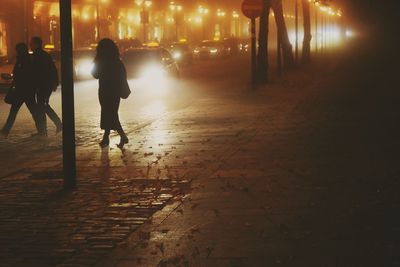 People walking on footpath at night
