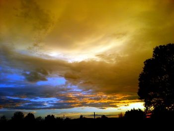 Silhouette of trees against cloudy sky