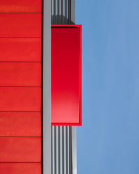 Low angle view of red building against clear blue sky