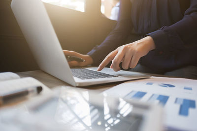 Midsection of man using laptop on table