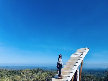 Man standing against blue sky