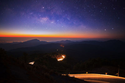 Scenic view of illuminated mountains against sky at night