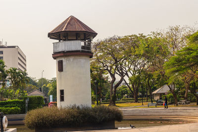 Street amidst trees and buildings against sky