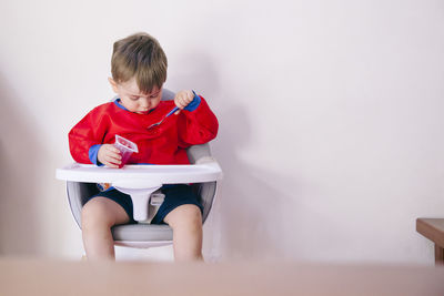 Rear view of boy looking at while sitting on seat