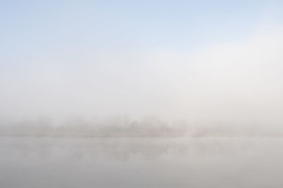 Scenic view of foggy landscape against sky