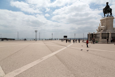 View of statue on road against cloudy sky