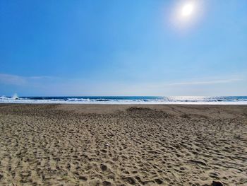 Scenic view of beach against blue sky