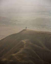 Distant view of man standing on mountain