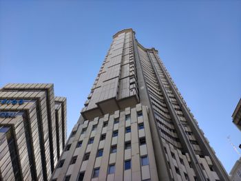 Low angle view of modern building against clear blue sky