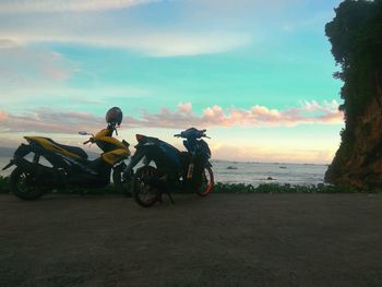 Horse riding motorcycle on beach against sky