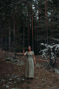 Mature woman standing in forest