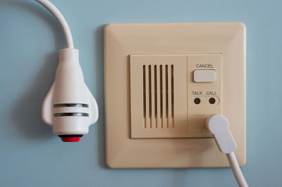 Close-up of telephone booth against white wall