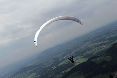 Aerial view of paragliding over sea against sky
