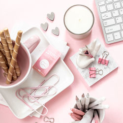 A feminine workspace, keyboard of a computer on a pink background with copy space