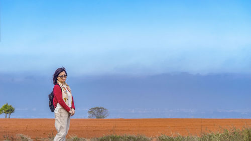 Woman standing on field against sky