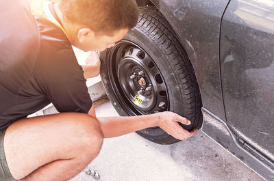 High angle view of man changing car tire