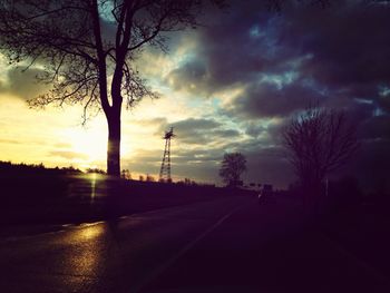 Silhouette of trees against cloudy sky at sunset