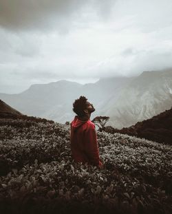 Rear view of man on arid landscape against sky