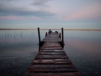 Pier over sea against sky during sunset