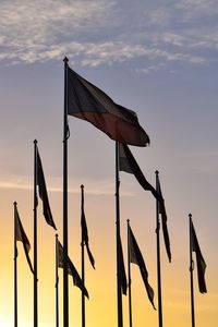 Low angle view of various national flags against sky during sunset