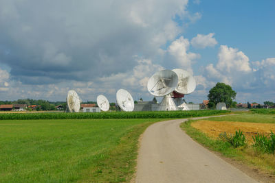 Radiotelescope on field against sky