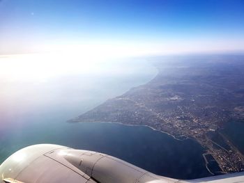 Aerial view of sea and mountains against clear blue sky