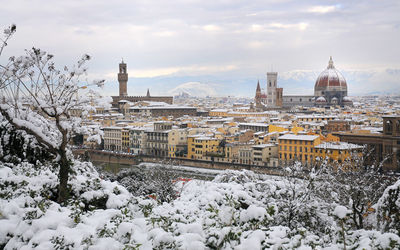 Buildings in city against sky during winter