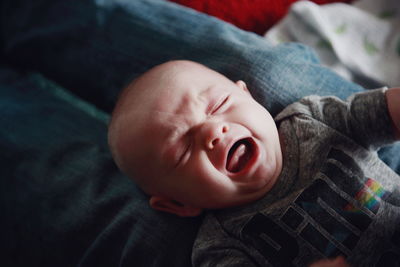 High angle view of baby boy crying on bed at home